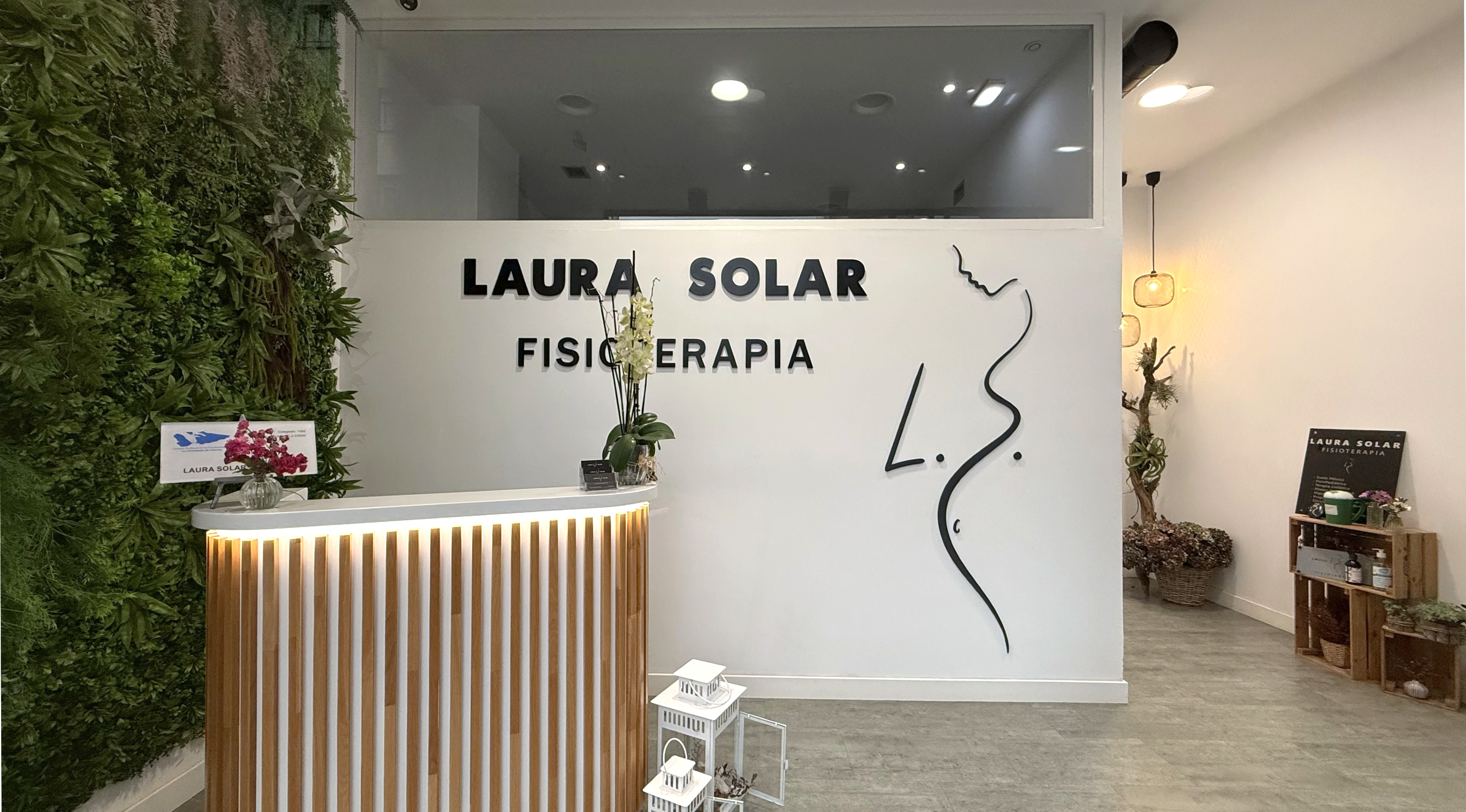 Recepción con jardín vertical y mostrador